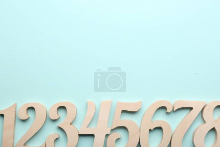 Photo for Wooden numbers on light background, flat lay. Space for text - Royalty Free Image