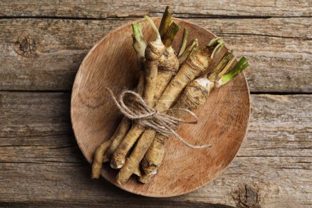 Photo for Bunch of fresh horseradish roots on wooden table, top view - Royalty Free Image
