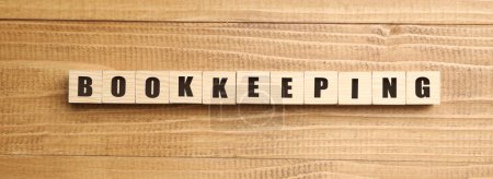 Word Bookkeeping made with cubes on wooden table, top view