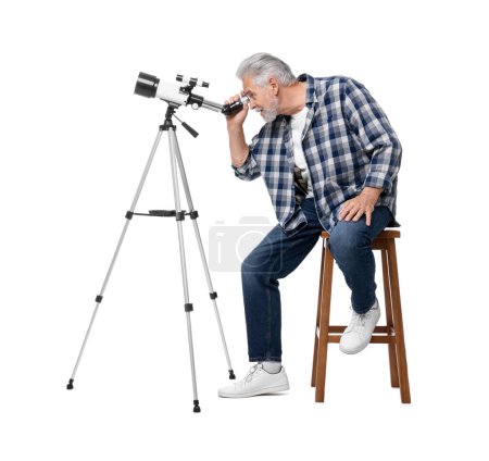 Astronome senior regardant les étoiles à travers le télescope sur fond blanc