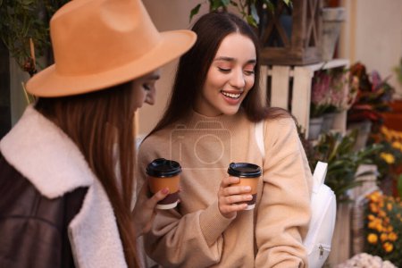 Téléchargez les photos : Heureux amis avec des tasses en papier de café à l'extérieur - en image libre de droit