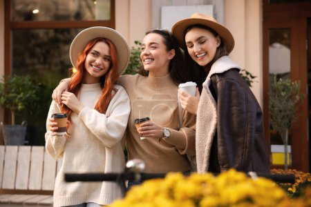 Téléchargez les photos : Heureux amis avec des tasses en papier de café près du café en plein air - en image libre de droit