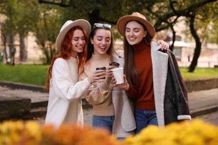 Téléchargez les photos : Heureux amis avec des tasses en papier de café dans le parc - en image libre de droit