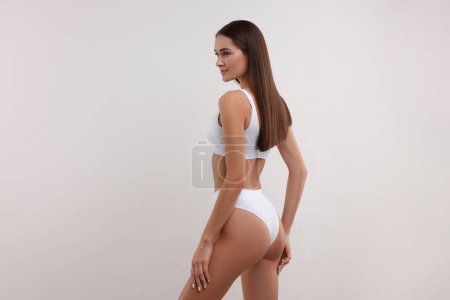 Téléchargez les photos : Jeune femme en bikini élégant sur fond blanc - en image libre de droit
