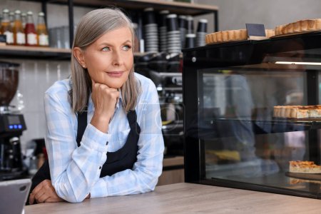 Photo for Portrait of smiling business owner at cashier desk in her cafe - Royalty Free Image