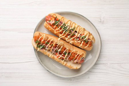 Photo for Delicious hot dogs with bacon, carrot and parsley on white wooden table, top view - Royalty Free Image