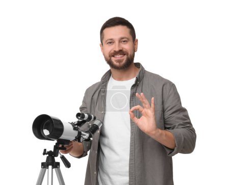 Happy astronomer with telescope showing ok gesture on white background