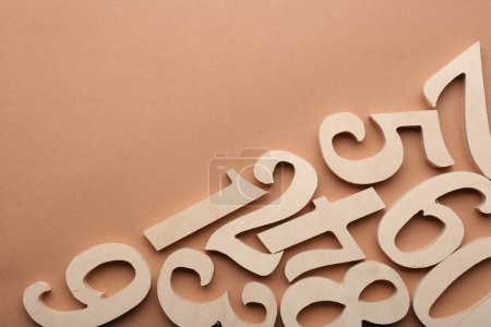 Photo for Wooden numbers on beige background, flat lay. Space for text - Royalty Free Image