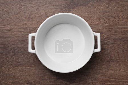 Photo for One white empty pot on wooden table, top view - Royalty Free Image