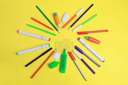 Rahmen verschiedener Schulsachen auf gelbem Hintergrund, flach liegend mit Platz für Text. Zurück zur Schule