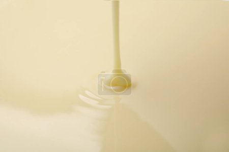 Téléchargez les photos : Vue rapprochée de la coulée de lait condensé. Produits laitiers - en image libre de droit