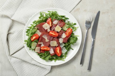 Photo for Delicious bresaola salad with parmesan cheese served on light grey textured table, flat lay - Royalty Free Image