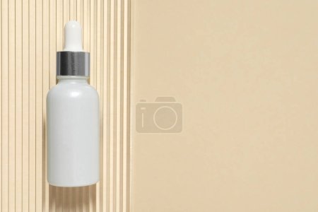 Photo for Bottle of cosmetic serum on beige background, top view. Space for text - Royalty Free Image