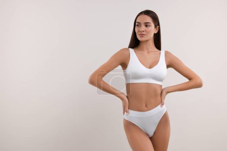 Foto de Mujer joven en bikini elegante sobre fondo blanco. Espacio para texto - Imagen libre de derechos