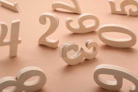 Photo for Many different wooden numbers on beige background - Royalty Free Image