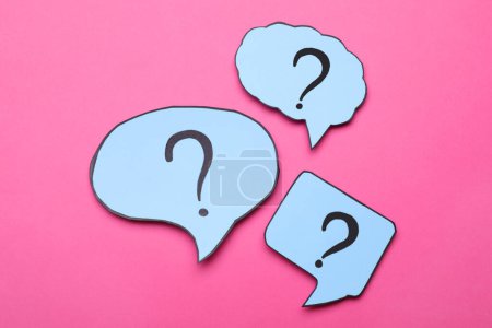 Photo for Different paper speech bubbles with question marks on pink background, flat lay - Royalty Free Image