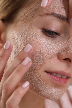 Woman applying face mask, closeup. Spa treatments