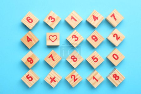 Photo for Wooden cubes with numbers and different symbols on light blue background, flat lay - Royalty Free Image