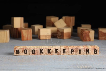 Word Bookkeeping made with cubes on light grey wooden table