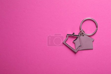 Téléchargez les photos : Porte-clés métalliques en forme de maisons sur fond rose vif, vue de dessus. Espace pour le texte - en image libre de droit