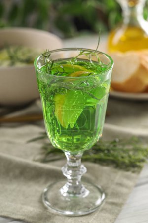 Photo for Delicious drink with tarragon in glass on white table - Royalty Free Image