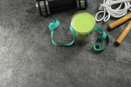 Photo for Tasty shake, sports equipment and measuring tape on stone table, above view with space for text. Weight loss - Royalty Free Image