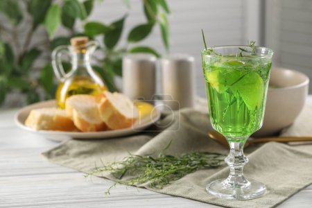 Photo for Delicious drink with tarragon in glass on white wooden table. Space for text - Royalty Free Image