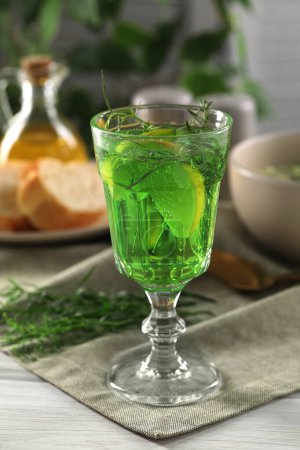 Photo for Delicious drink with tarragon in glass on white wooden table - Royalty Free Image