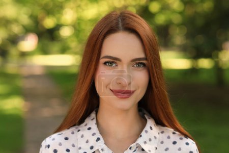 Photo for Portrait of beautiful young woman with red hair outdoors. Attractive lady looking into camera - Royalty Free Image