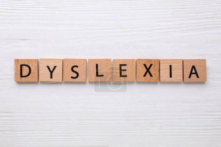 Tuiles avec mot Dyslexie sur table en bois blanc, pose plate