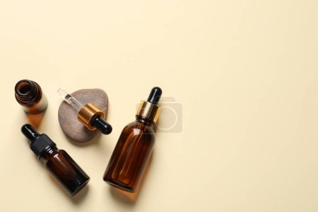 Photo for Flat lay composition with face serums on beige background. Space for text - Royalty Free Image