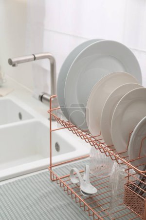 Photo for Drying rack with clean dishes on countertop near sink in kitchen - Royalty Free Image