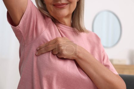 Woman doing breast self-examination at home, closeup