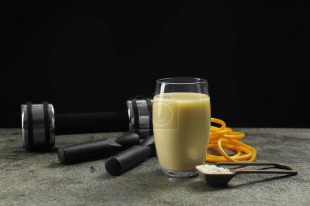 Photo for Tasty shake, sports equipment and powder on grey table against black background. Weight loss - Royalty Free Image