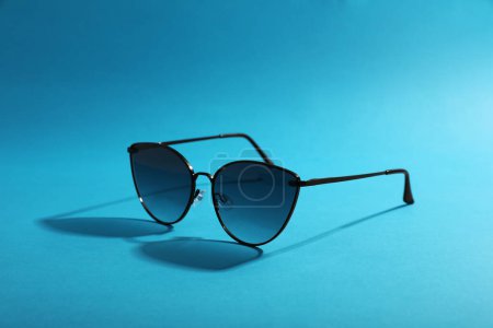 Sunglasses on light blue background. Stylish accessory