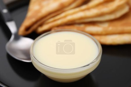 Savoureux lait condensé et crêpes sur plaque, gros plan