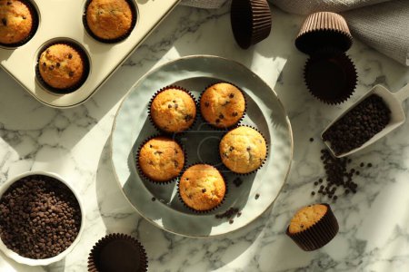 Photo for Delicious sweet muffins with chocolate chips on white marble table, flat lay - Royalty Free Image