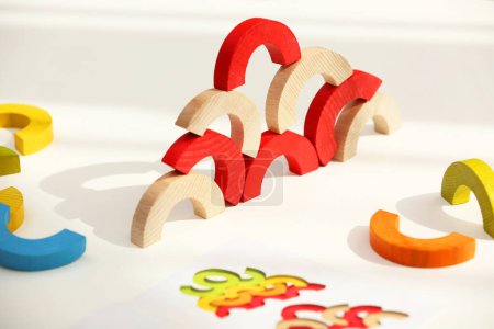 Colorful wooden pieces of play set on white table. Educational toy for motor skills development