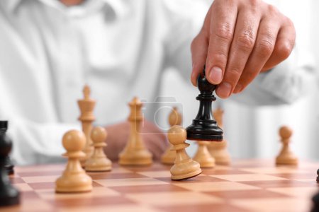 Hombre moviendo pieza de ajedrez en el tablero de ajedrez, primer plano