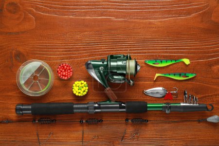 Fishing tackle on wooden table, flat lay. Space for text