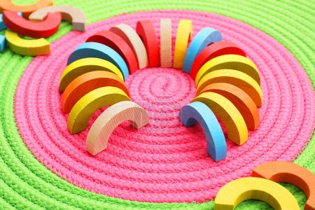 Colorful wooden pieces of playing set on color mat. Educational toy for motor skills development