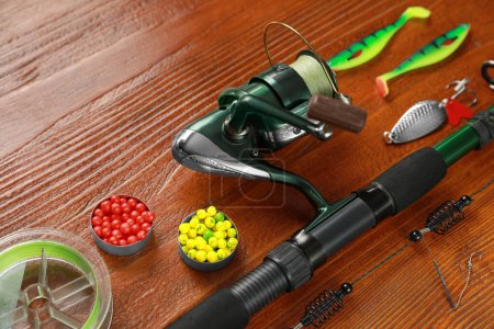 Photo for Fishing tackle. Reel, rod, lures and different baits on wooden table - Royalty Free Image