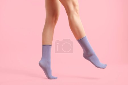 Woman in stylish purple socks on pink background, closeup