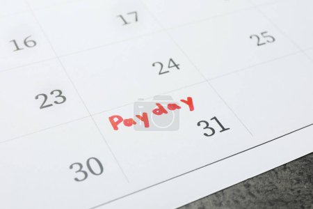 Photo for Calendar page with marked payday date on table, closeup - Royalty Free Image