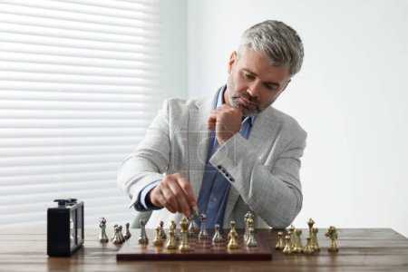 Hombre jugando ajedrez durante el torneo en la mesa en el interior