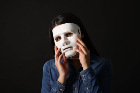 Multiples Persönlichkeitskonzept. Frau in Maske auf schwarzem Hintergrund