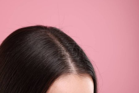 Téléchargez les photos : Femme aux cheveux noirs sains sur fond rose, gros plan. Espace pour le texte - en image libre de droit