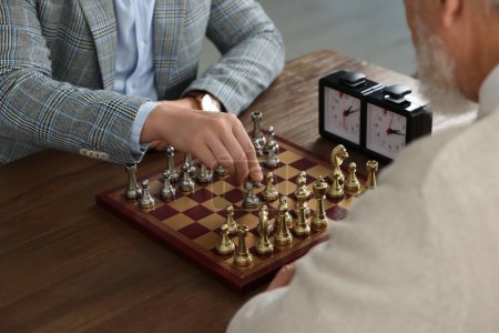 Hommes jouant aux échecs pendant le tournoi à une table en bois, gros plan