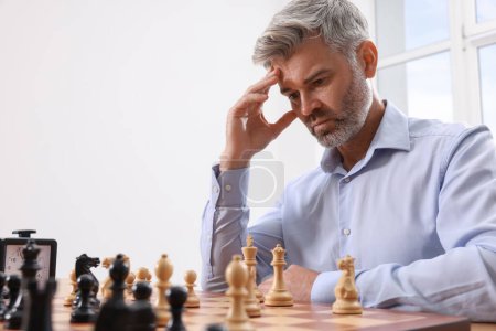 Homme jouant aux échecs pendant le tournoi à la table à l'intérieur