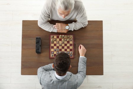 Männer beim Schachspiel während eines Turniers am Holztisch, oben Blick